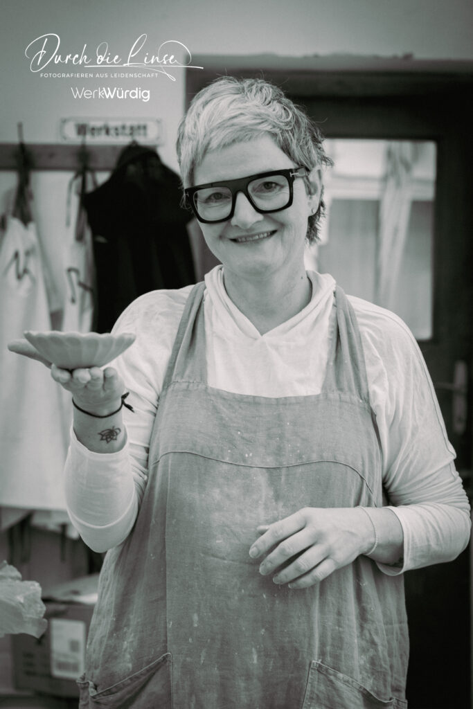 Keramikerin Niki Baumberger mit einem Werkstück in der Hand.