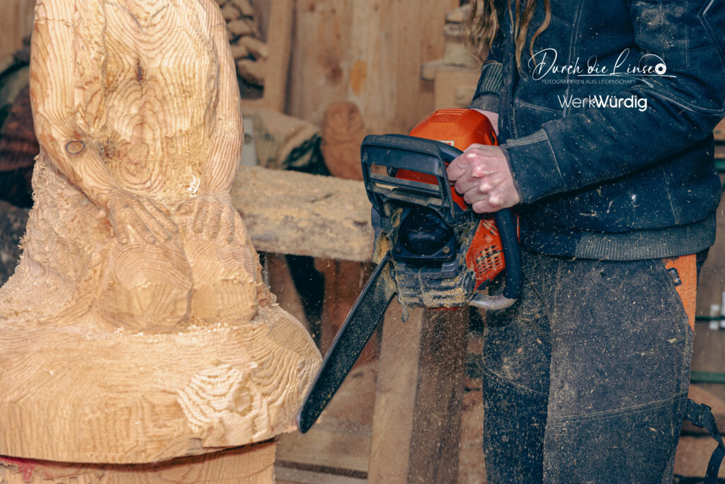 Holzkünstlerin Lisa Hirschbichler arbeitet mit der Motorsäge an einer Holzskulptur.