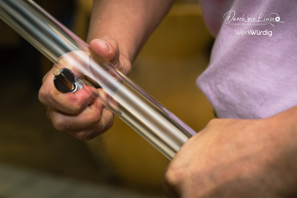 Anna Huber, die Glasbläserin beim schneiden eines Glasrohres.