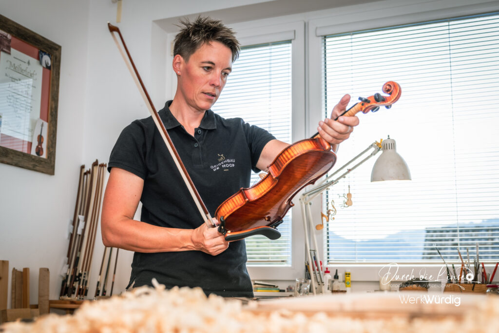 Johanna De Hoop beim Ansehen einer Geige