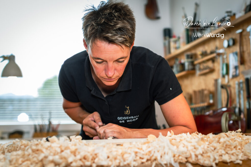 Johanna De Hoop beim Holzschnitten an der Geige